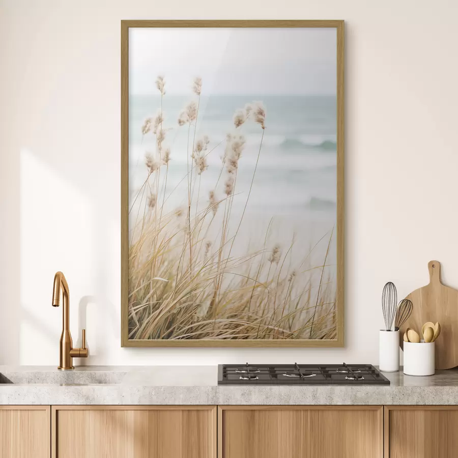 Fototapeta Wysoka trawa z puszystymi główkami nasion, piaszczysta plaża i fale oceanu w tle, miękka i stonowana paleta kolorów f45561